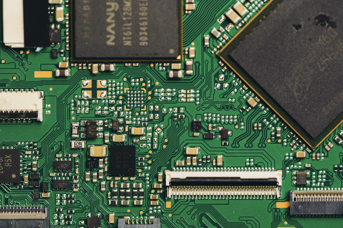 Primer plano real de una placa de circuito con chips, condensadores y conectores FPC